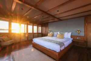 Master Stateroom on Celestia with king bed and sunset light through panoramic windows