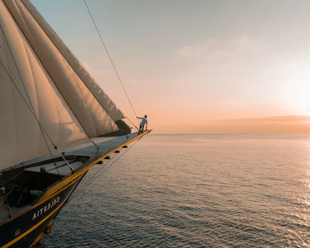 The seven sails of the Celestia phinisi yacht raised at sea