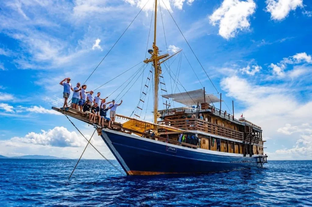 Mari phinisi and crew on the bowsprit