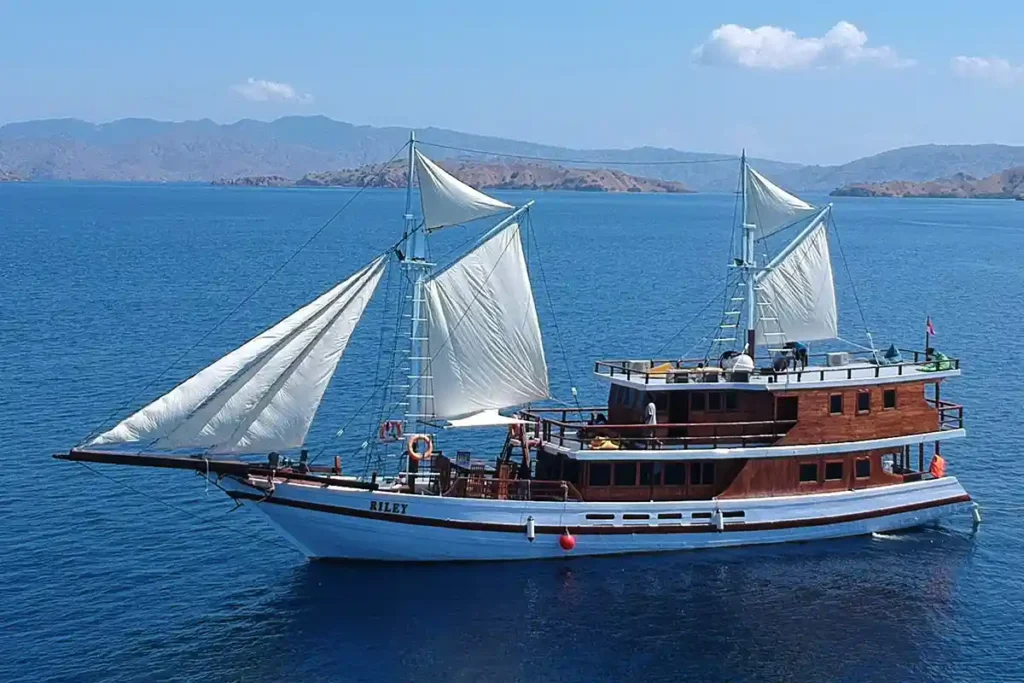 Side view of Riley phinisi cruising near Labuan Bajo