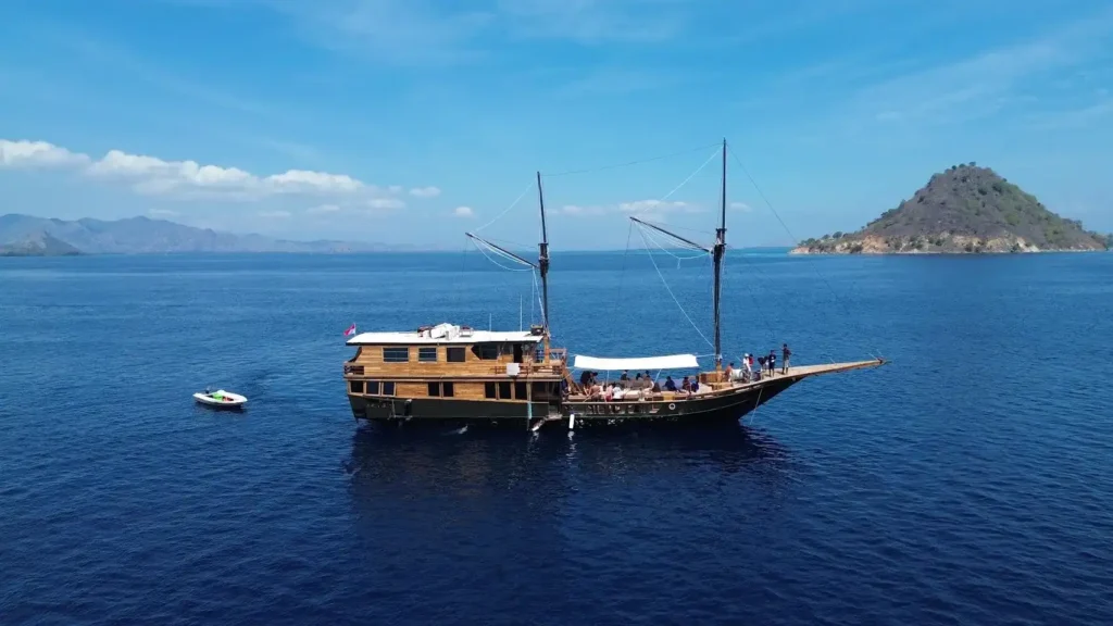 Broadside aerial view of Blackbeard Phinisi with an island backdrop
