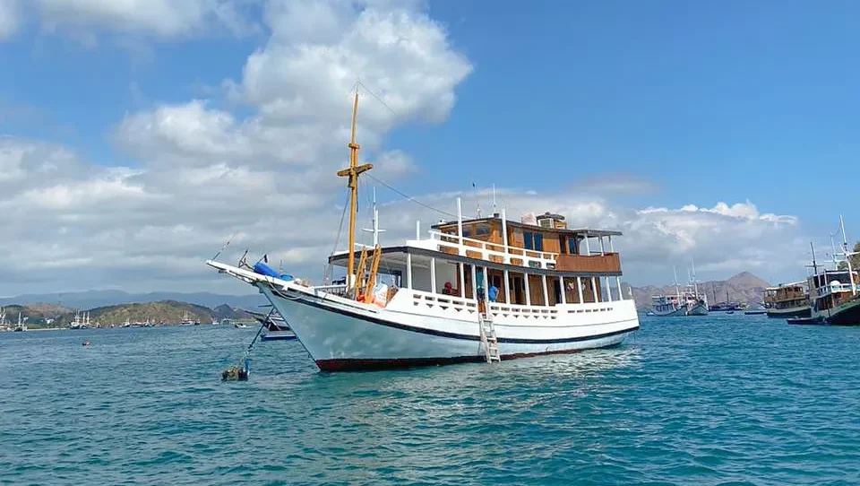 Front-quarter view of North Blue Phinisi anchored near Labuan Bajo